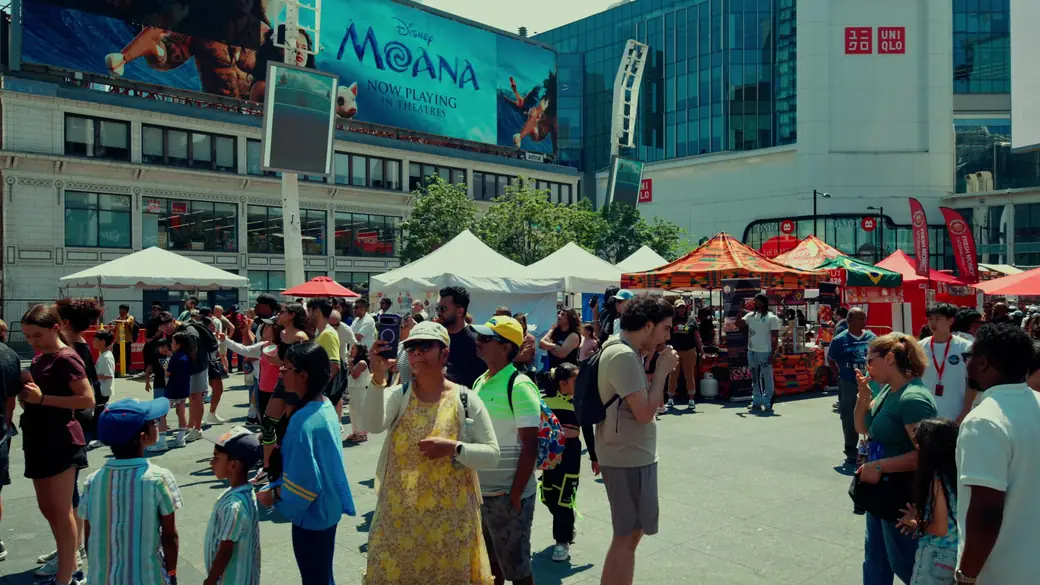 Visitors walk between vendor tents at Sankofa Square