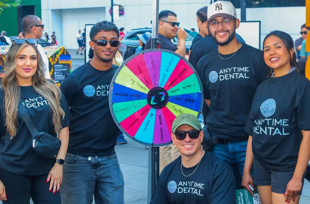 The Anytime Dental team with a prize wheel at their WorldFest activation