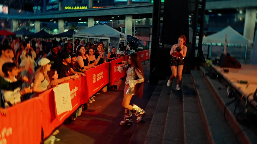 A performer sings along the barricade to fans at night