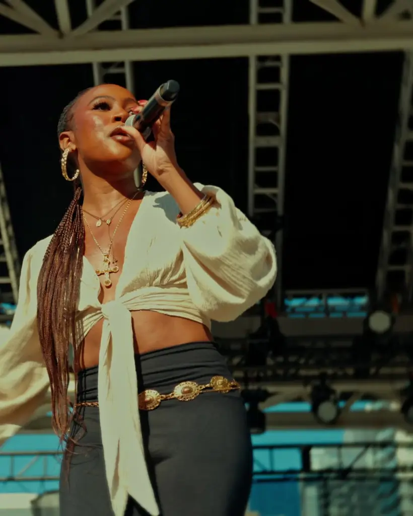 A singer in a white top performs on the WorldFest main stage