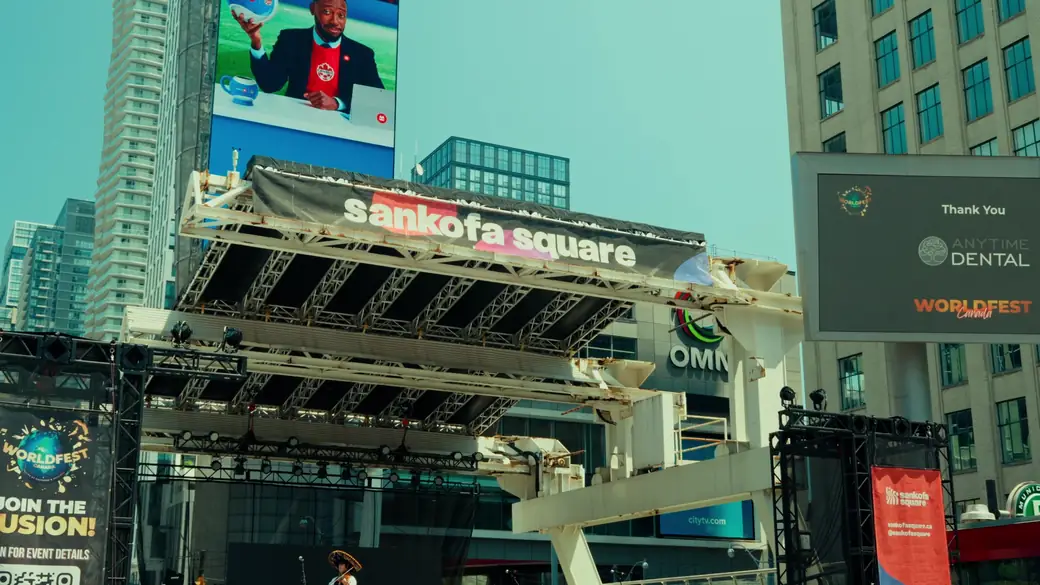 The Sankofa Square stage with a sponsor thank-you message for Anytime Dental on the big screen