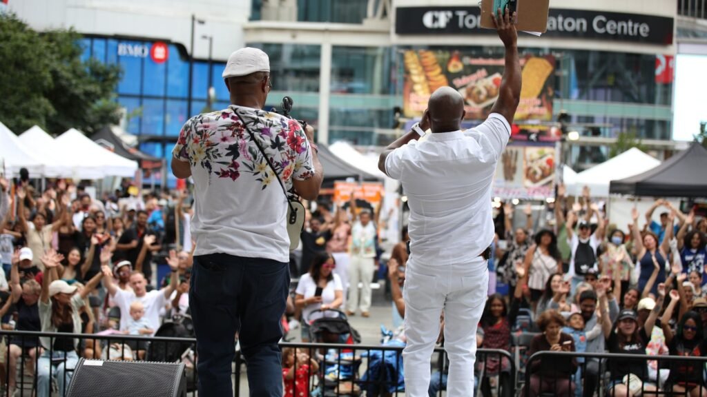 Toronto summer festival crowd enjoying food and live cultural performances.